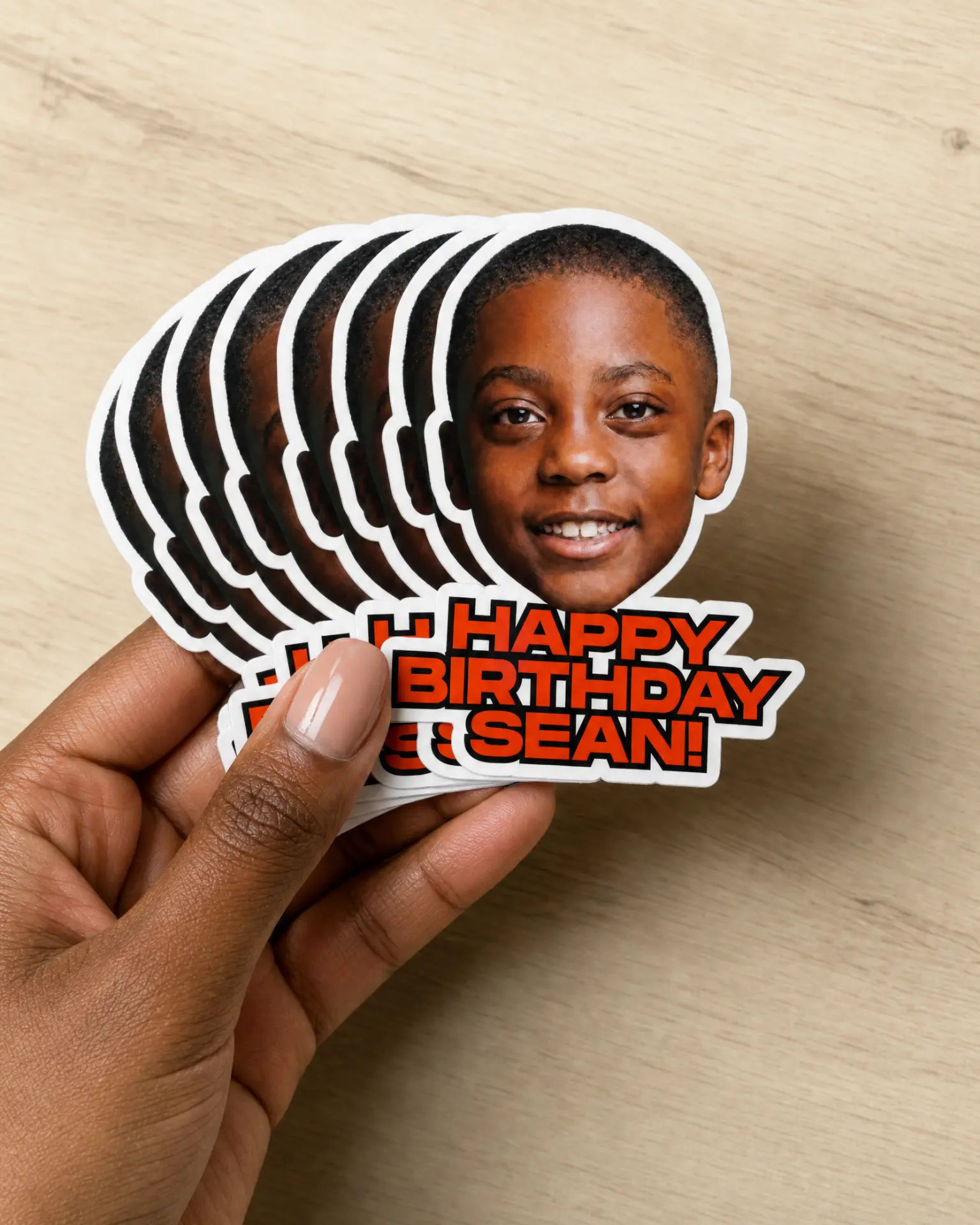 Hand holding a stack of Happy Birthday Sean die-cut stickers