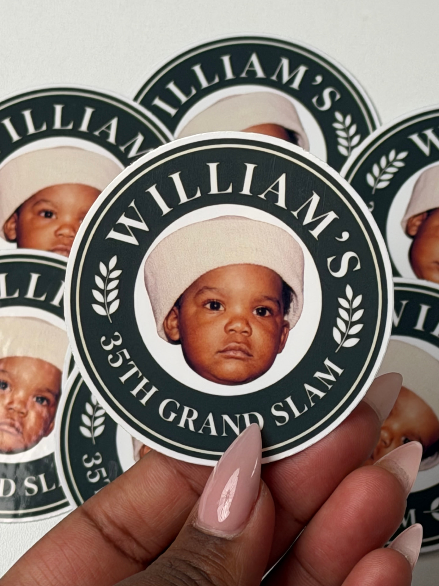 Hand peeling a William's 35th Grand Slam sticker from a sheet
