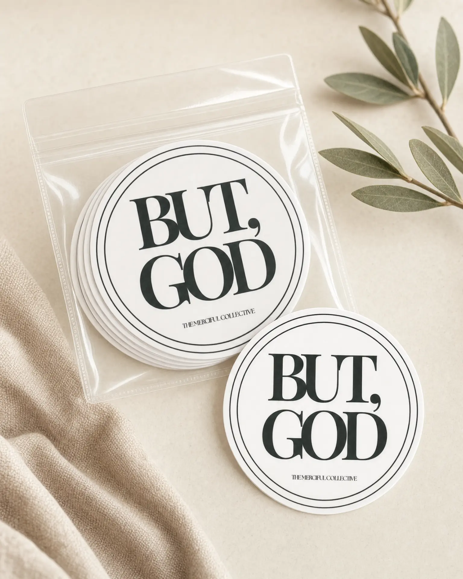 But, God round stickers in a clear pack beside eucalyptus